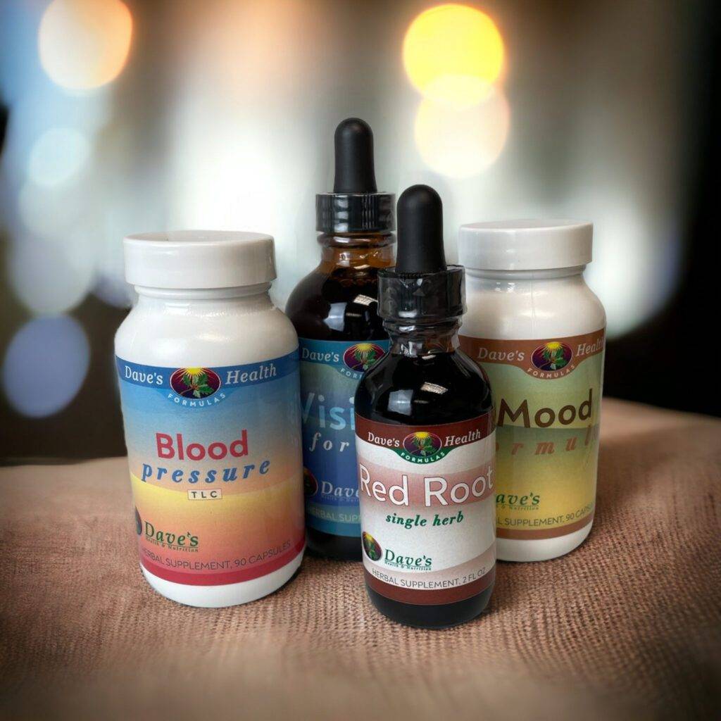 Red Root, Blood Pressure TLC, and Mood Formula. These are 4 herbal formulas. 2 are in liquid tincture bottles. They are sitting on a table with a blurred background.